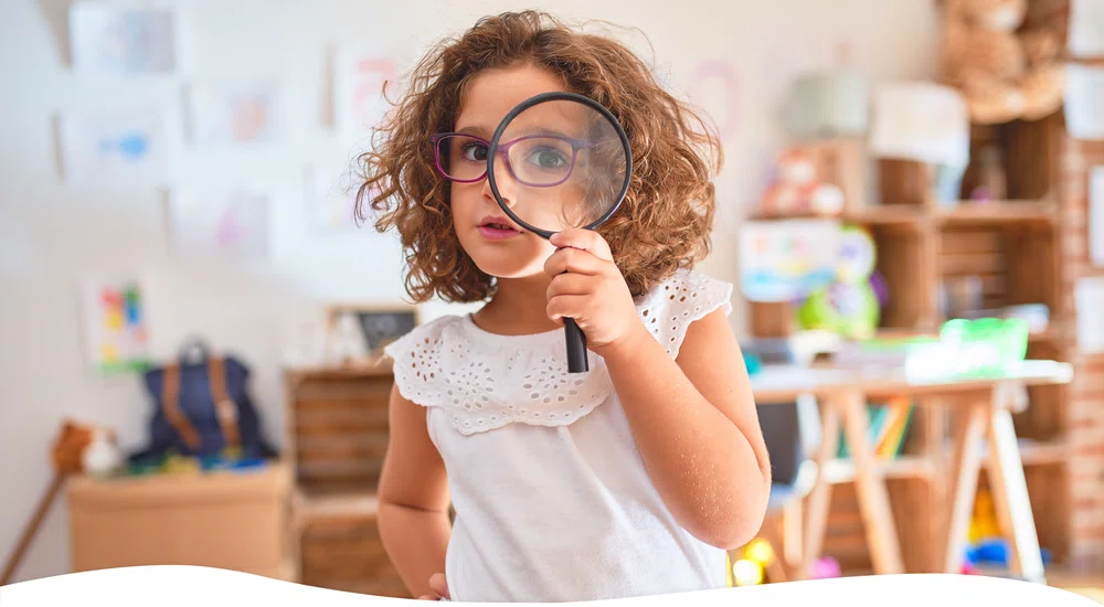 Girl holding a magnifying glass