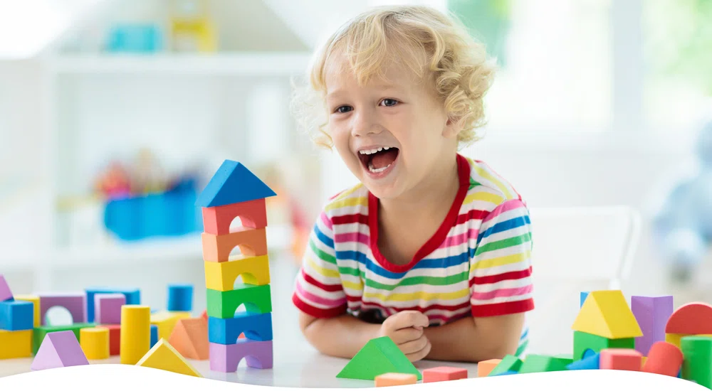 Child playing with brightly coloured wooden blocks