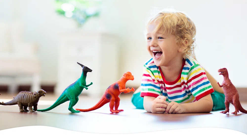 Child playing with dinosaur toys