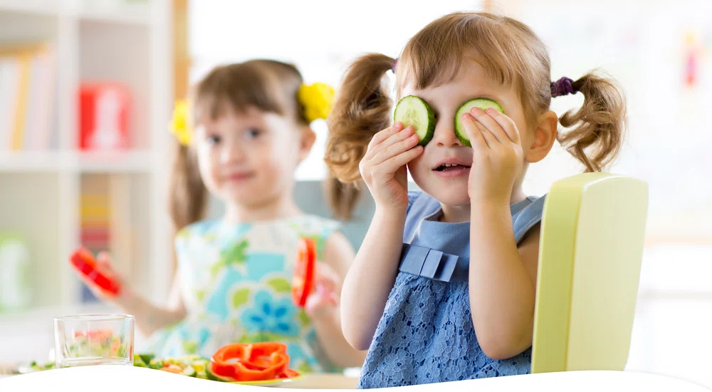 Girl covering eyes with cucumber