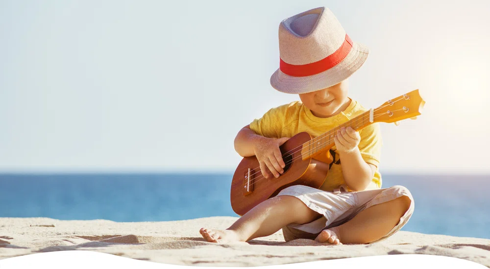 Boy playing guitar on beach